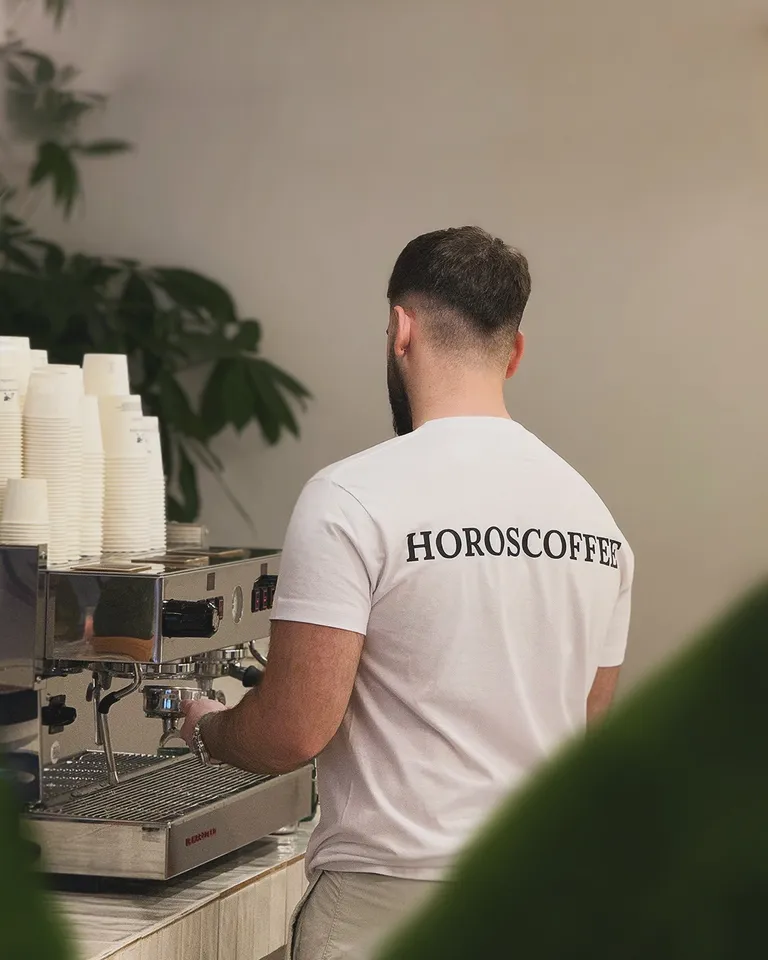 Barista de HOROSCOFFEE preparando café en la máquina
